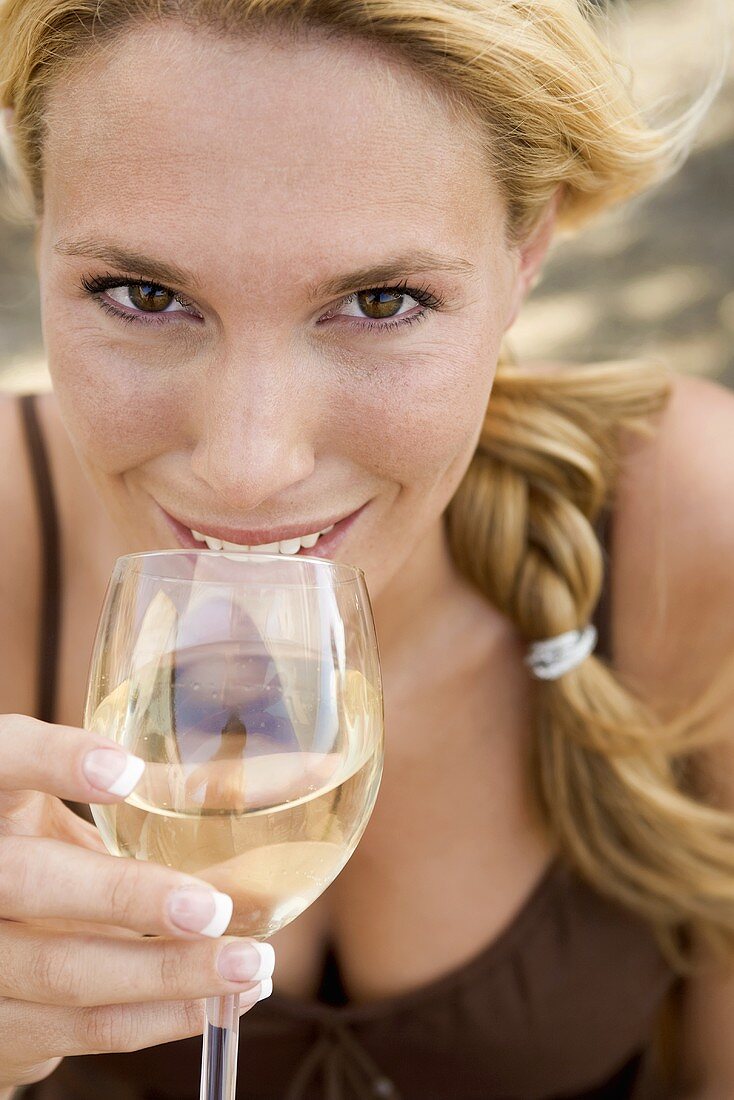 Blond woman drinking a glass of white wine