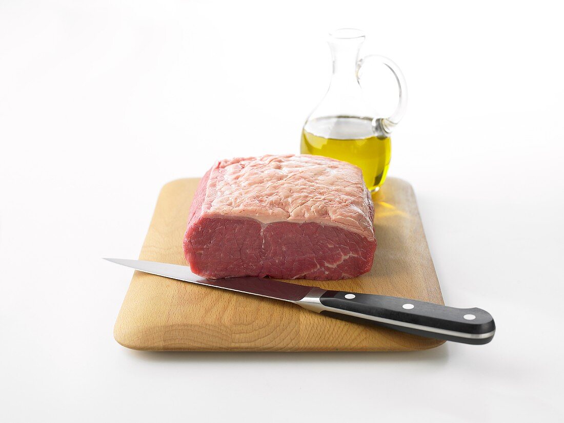 Raw rump steak on wooden board