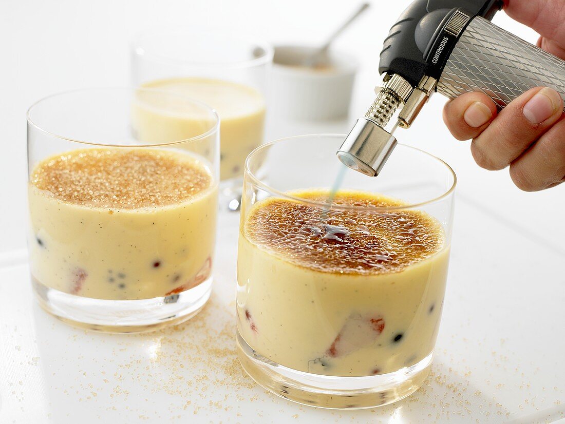 Caramelising sugar on crème brûlée using a blow torch