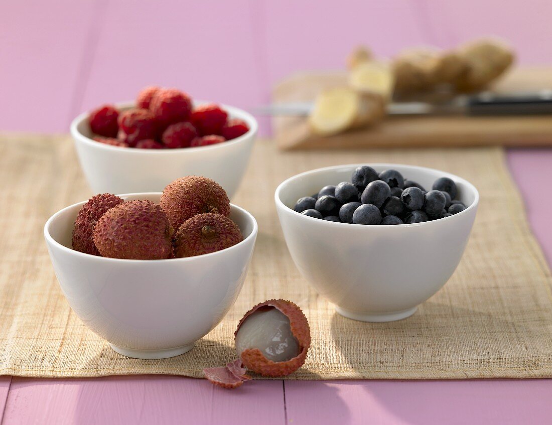 Lychees, blueberries and raspberries in small bowls