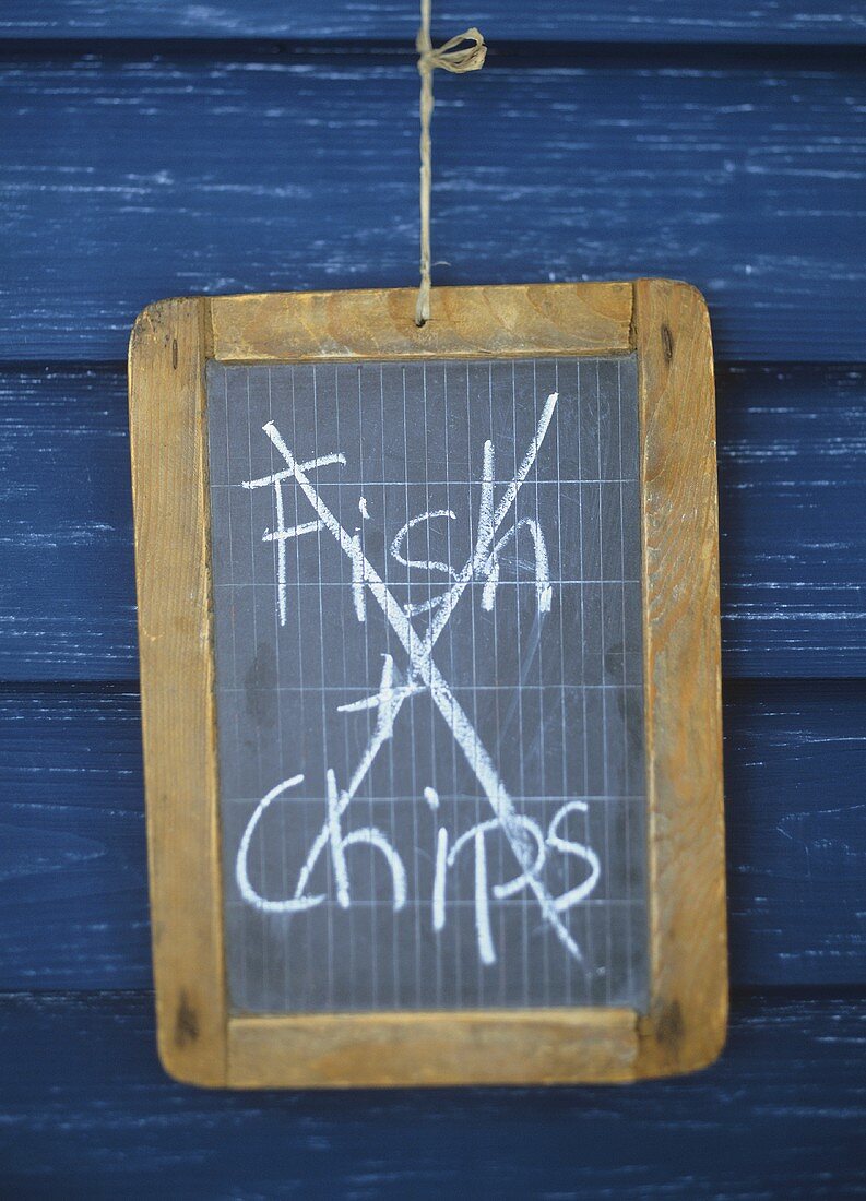 The words 'Fish & Chips' crossed out on a blackboard