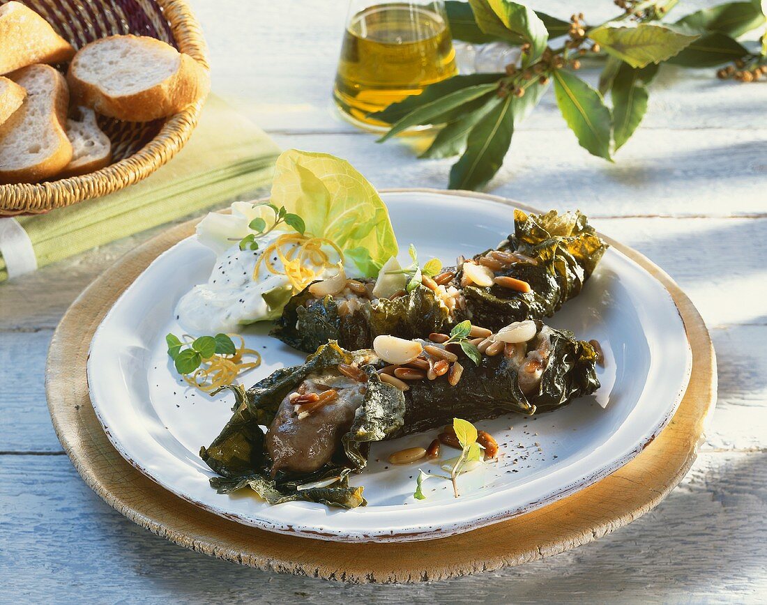 Sausages wrapped in vine leaves with pine nuts, tzatziki