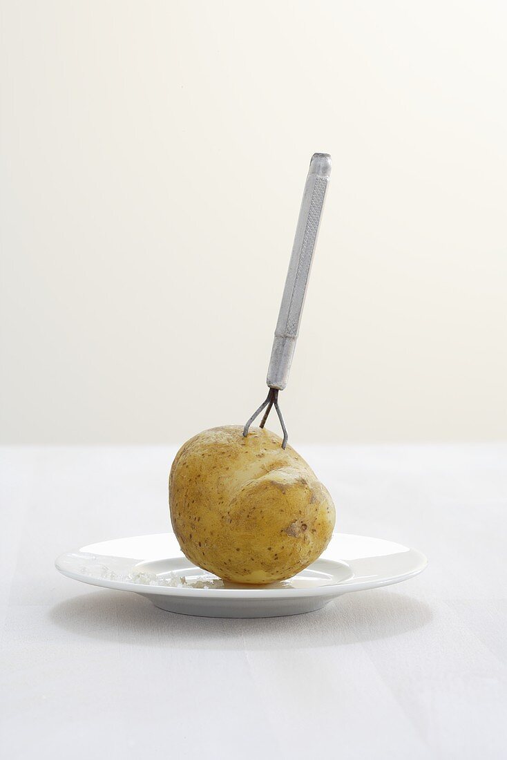 Boiled potato on potato peeling fork