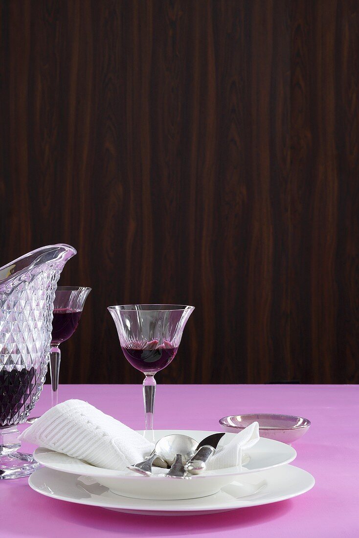 Elegant white tableware, fabric napkin and red wine