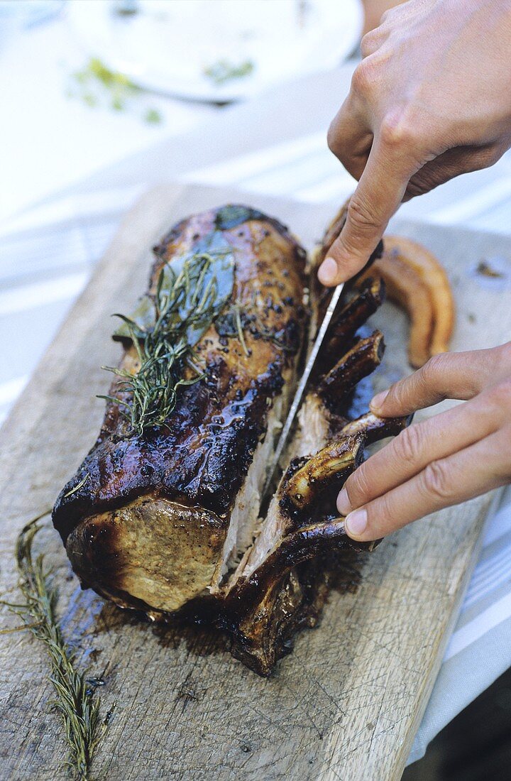 Removing the bones from roast loin of pork