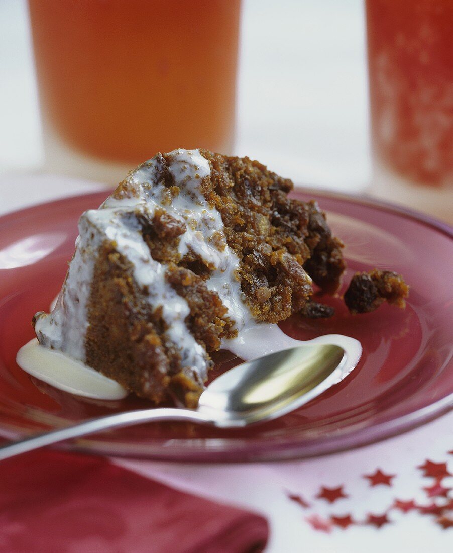 A piece of Christmas pudding with cream sauce (UK)