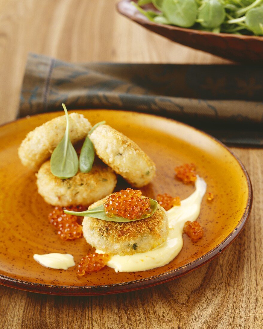 Fish cakes garnished with red caviar
