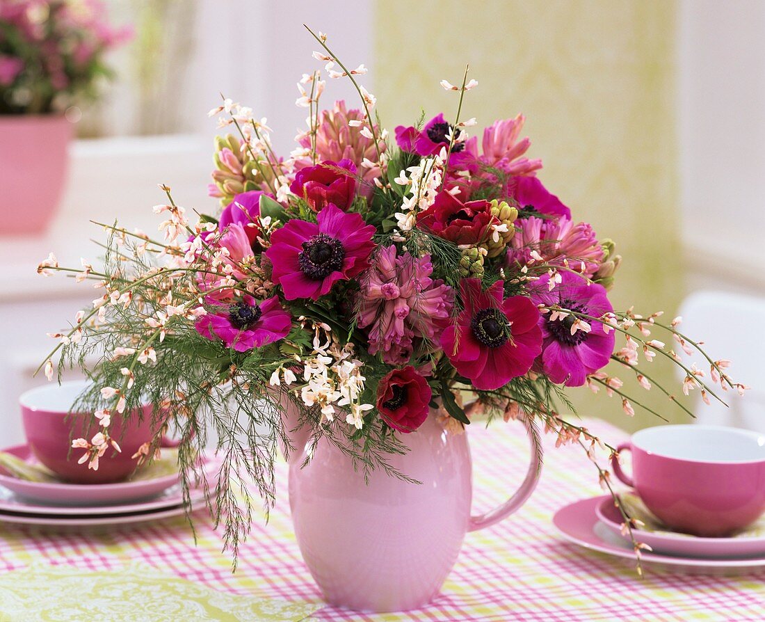 Poppy anemones, hyacinths, broom, asparagus fern in a jug