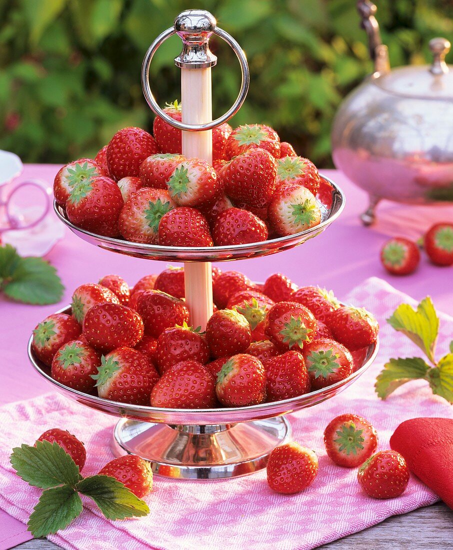 Fresh strawberries on a tiered stand on a garden table