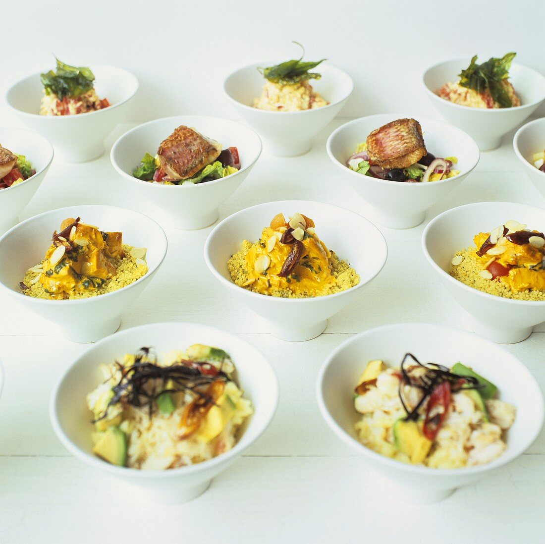 Assorted party salads in white bowls