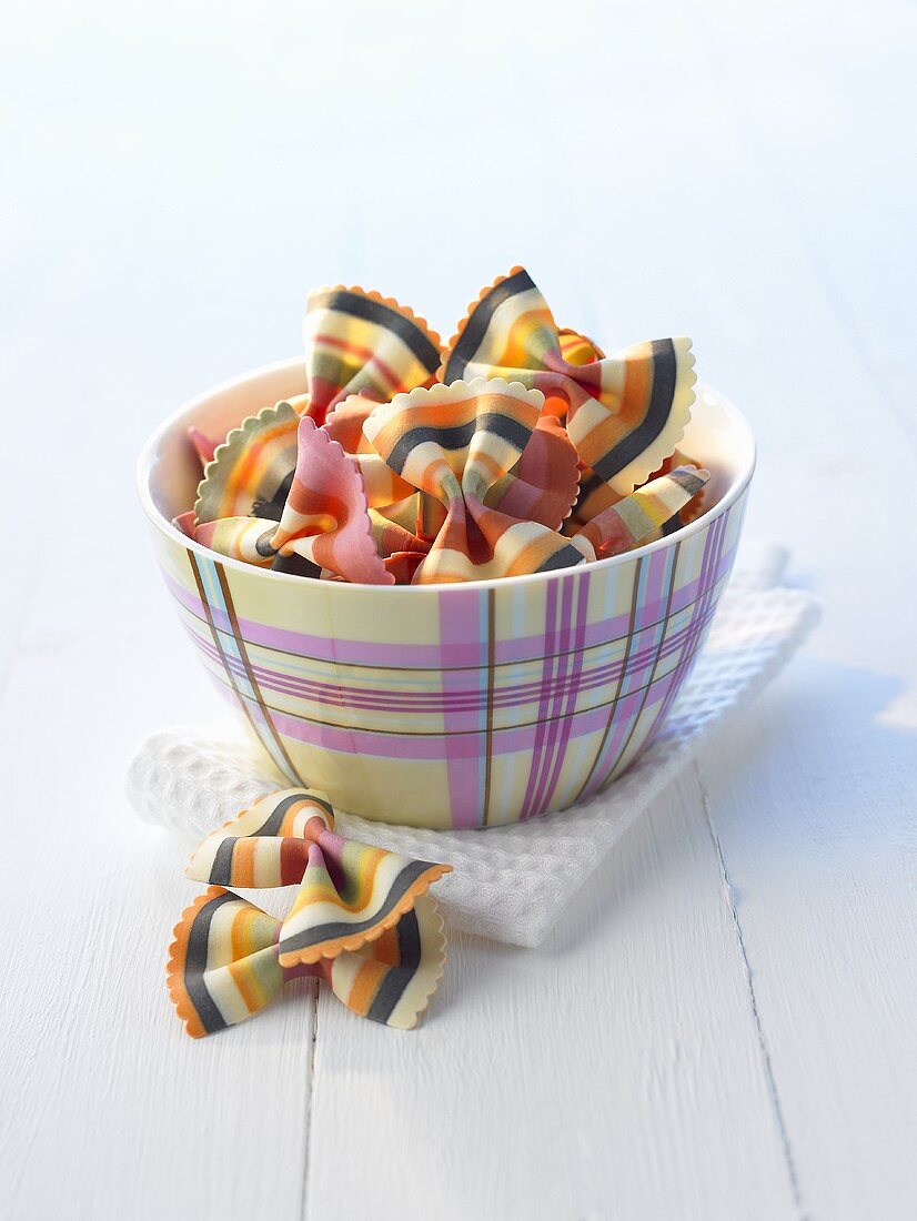 Multicoloured bow-tie pasta (farfalle) in a small bowl