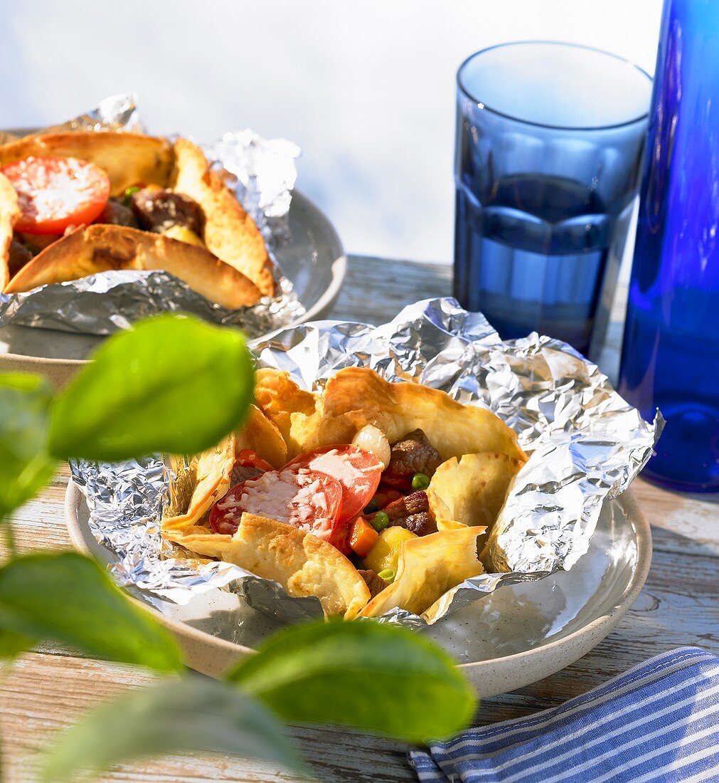 Lamb Kleftiko in foil with tomatoes and melted cheese