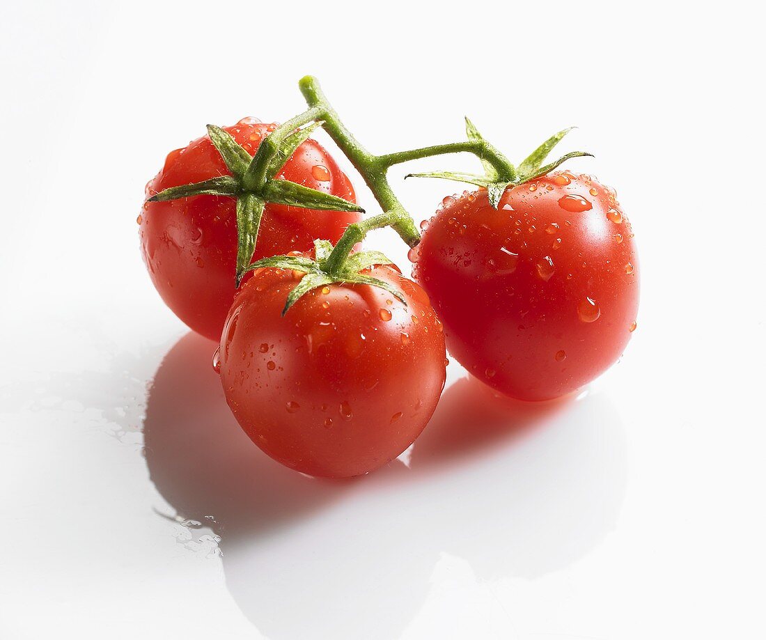 Drei Kirschtomaten mit Wassertropfen