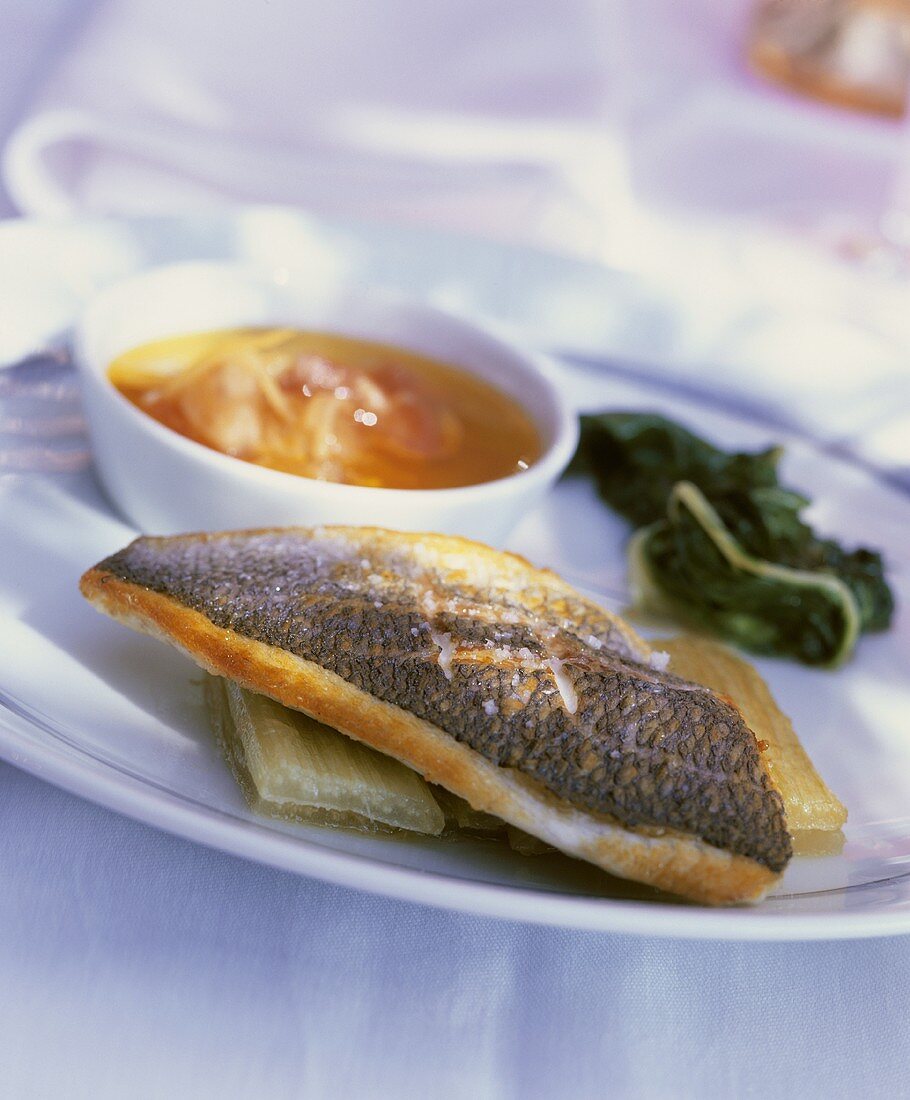Fried sea bass with spinach and tomato and lemon oil