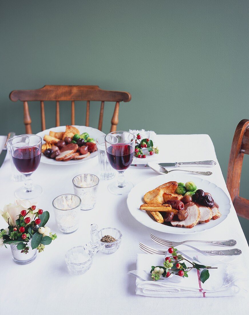 Laid table with plates of roast turkey (Christmas)