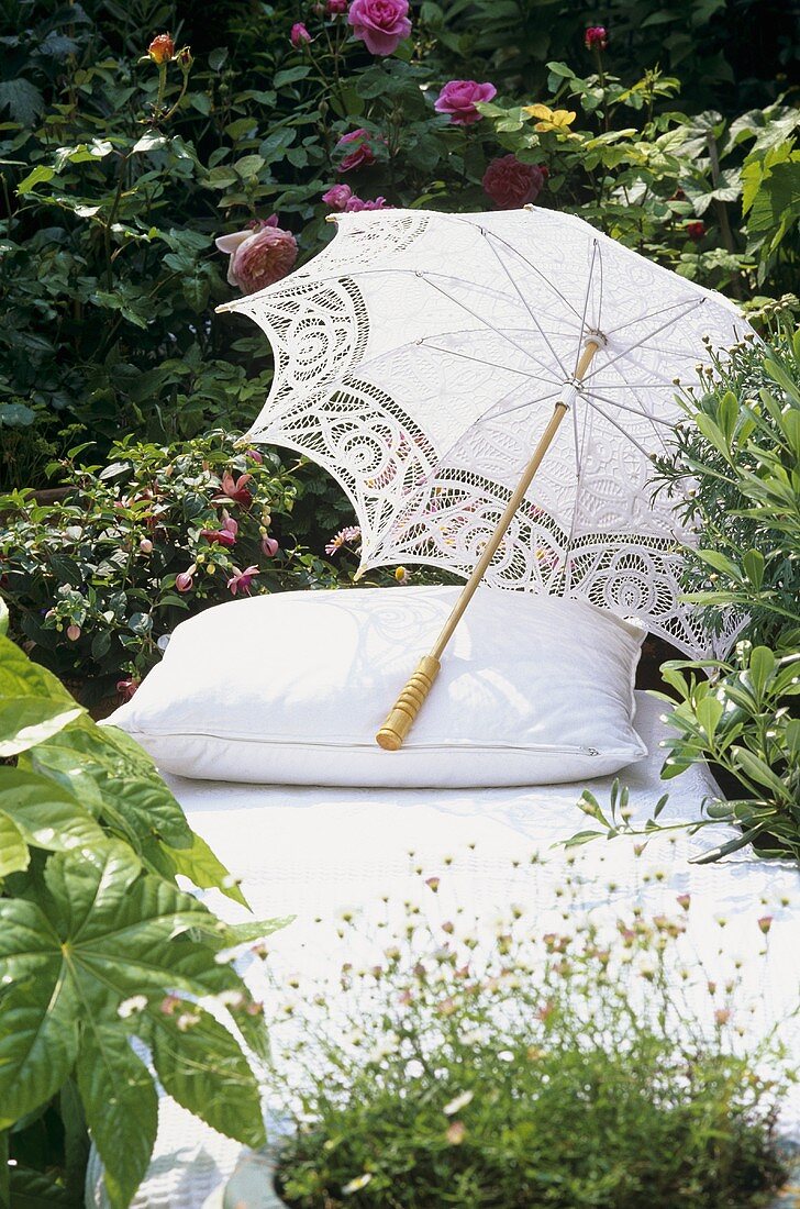 Liege mit Sonnenschirm im Garten