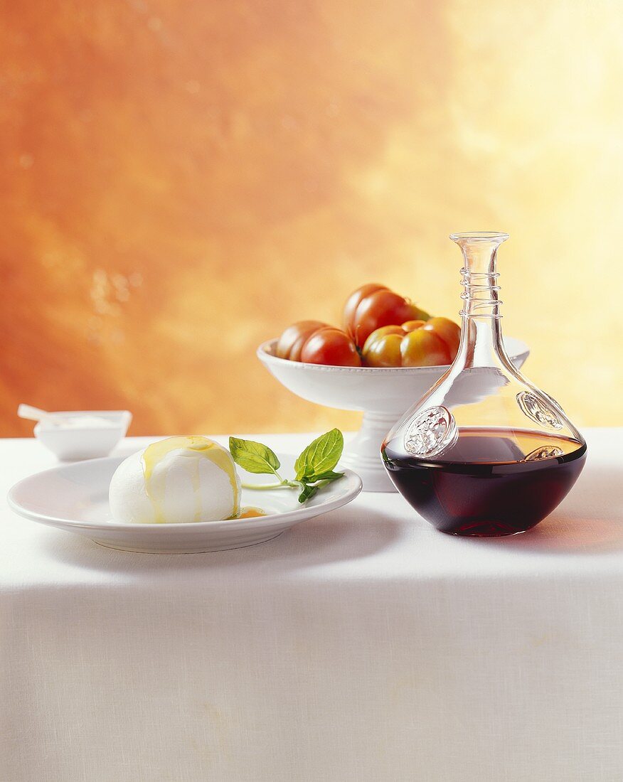 Still life with mozzarella, tomatoes and carafe of red wine