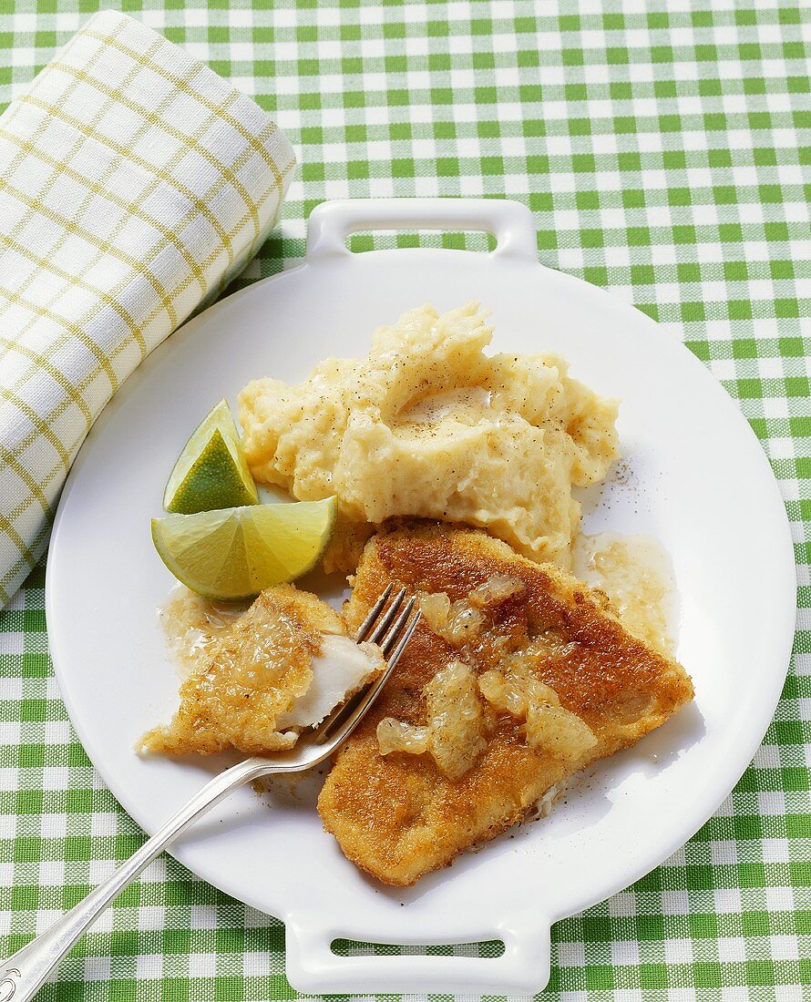 Escalope of coley with mashed potato and lime wedges