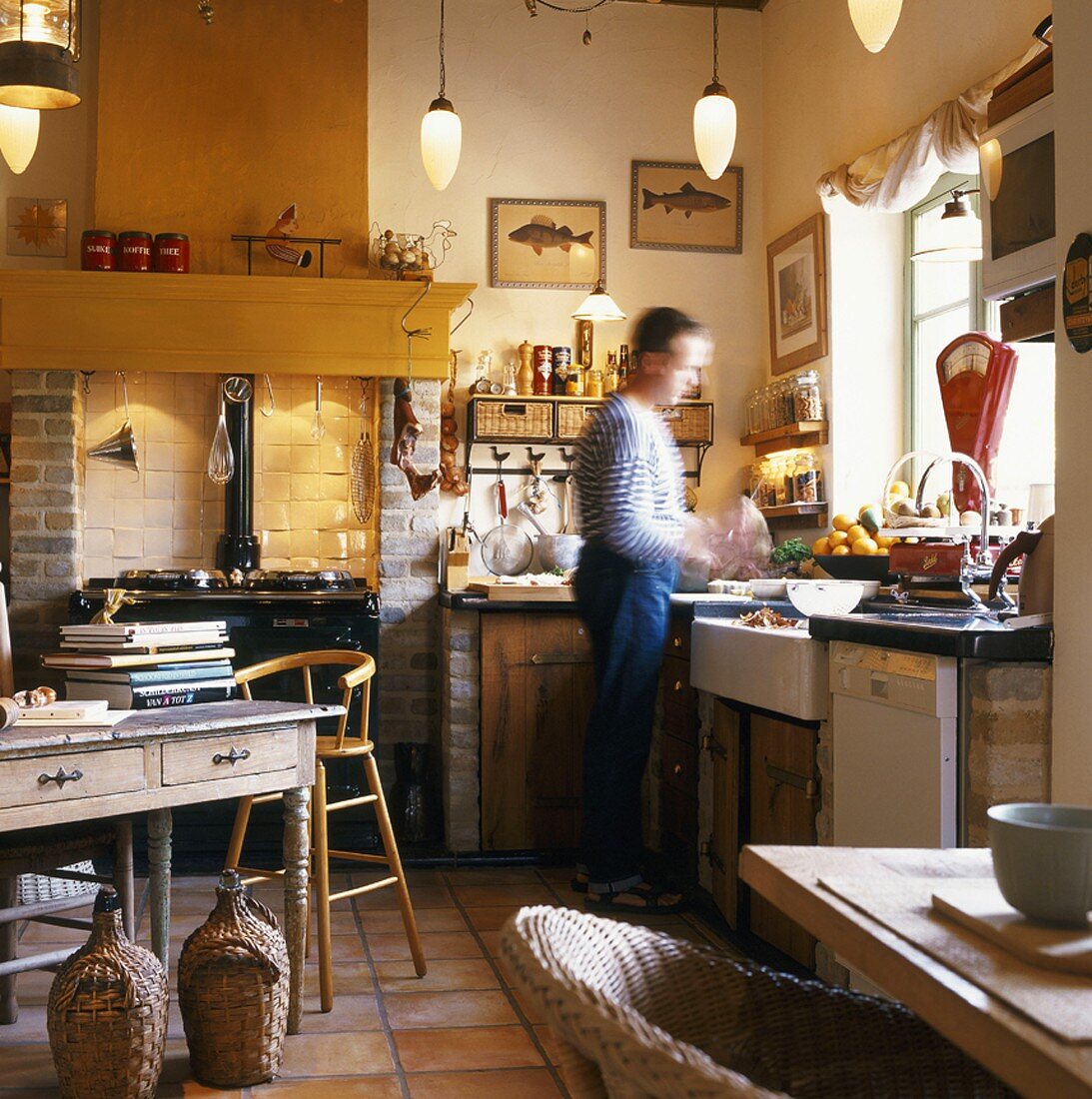 Landhausküche mit antikem Küchenofen und kochendem Mann
