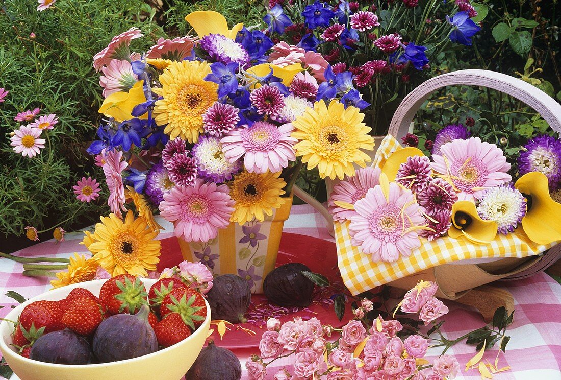 Vase of gerberas and mixed flowers, strawberries and figs