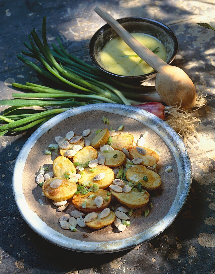 Potatoes with spring onions, pumpkin seeds, mustard dressing