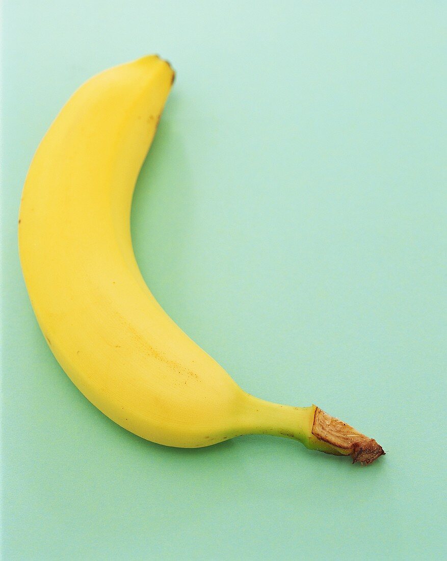 Eine Banane vor grünem Hintergrund