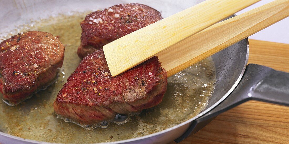 Frying fillet steaks in butter in a frying pan