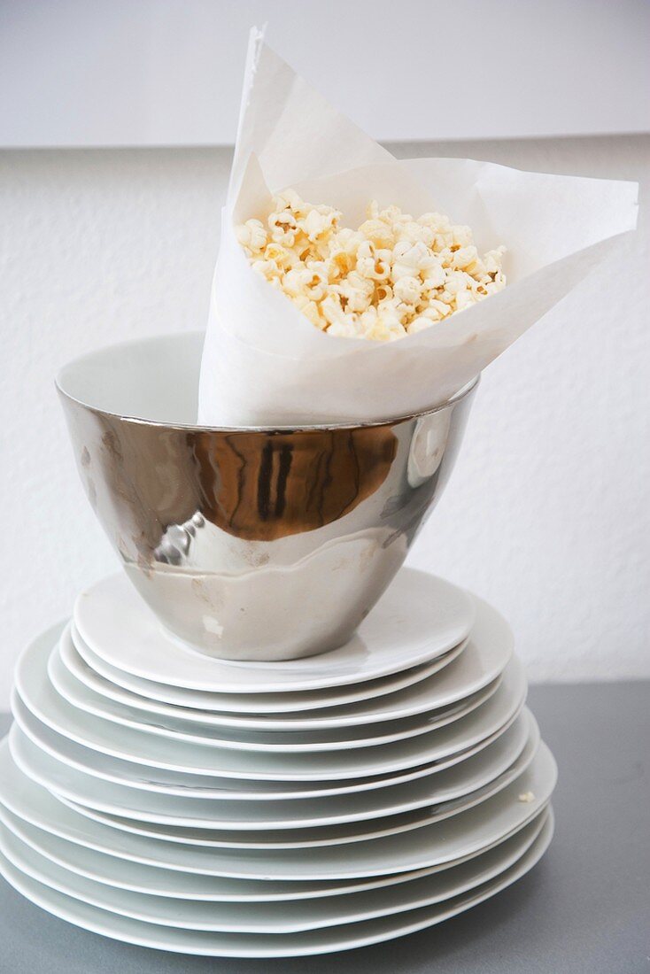 Teller gestapelt und Schale mit Popcorn
