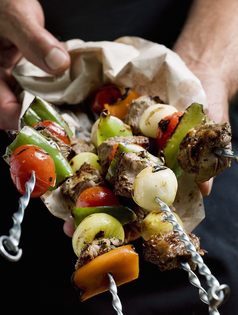 Holding grilled meat and vegetable kebabs