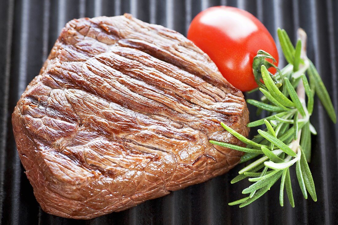 Grilled beef steak with rosemary and tomatoes
