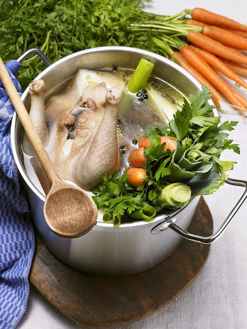 Suppenhuhn im Kochtopf mit Gemüse