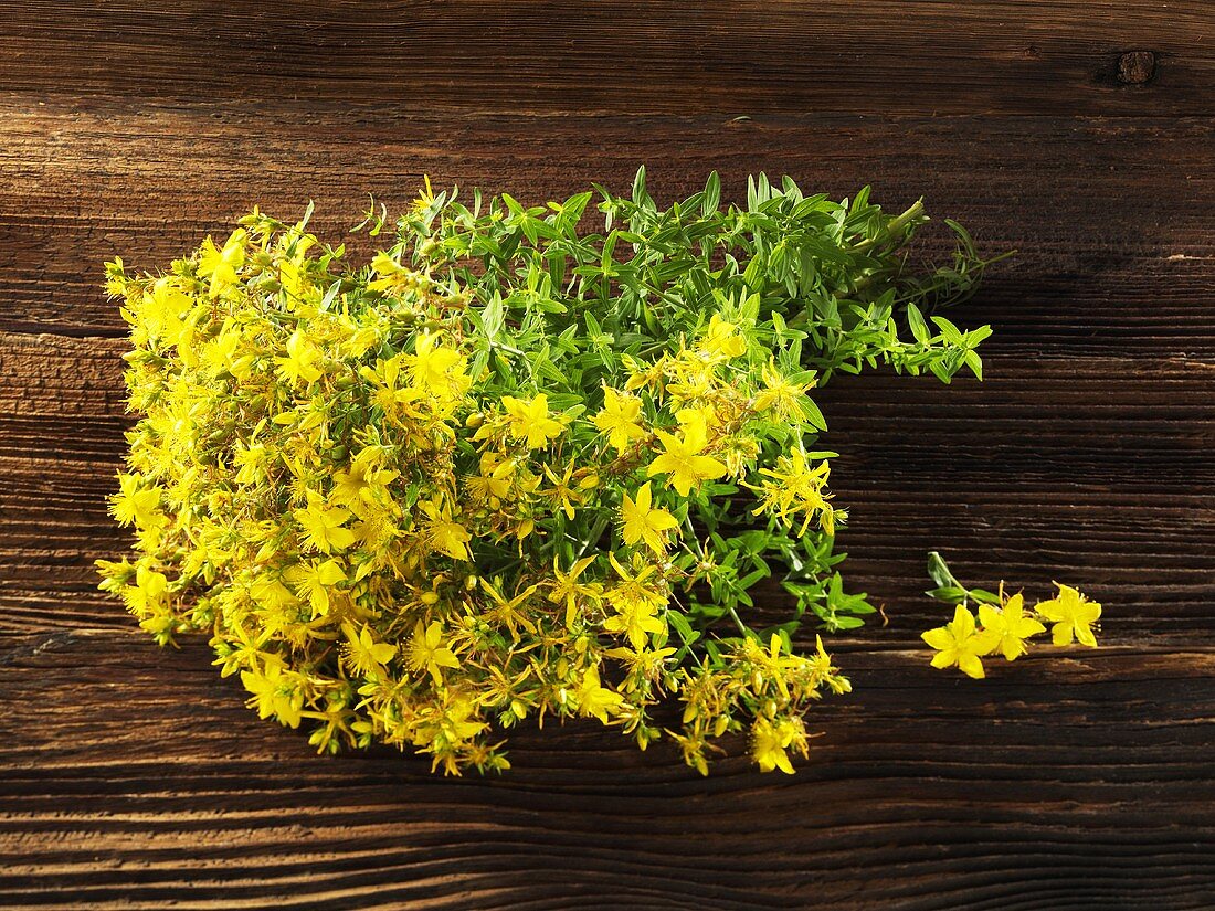 Flowering St. Johns wort on a wooden surface