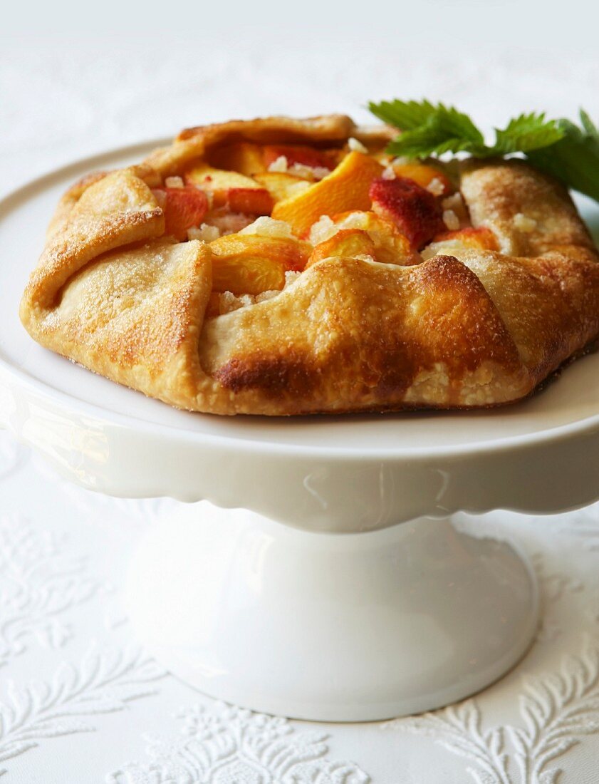 Peach galette on a cake stand
