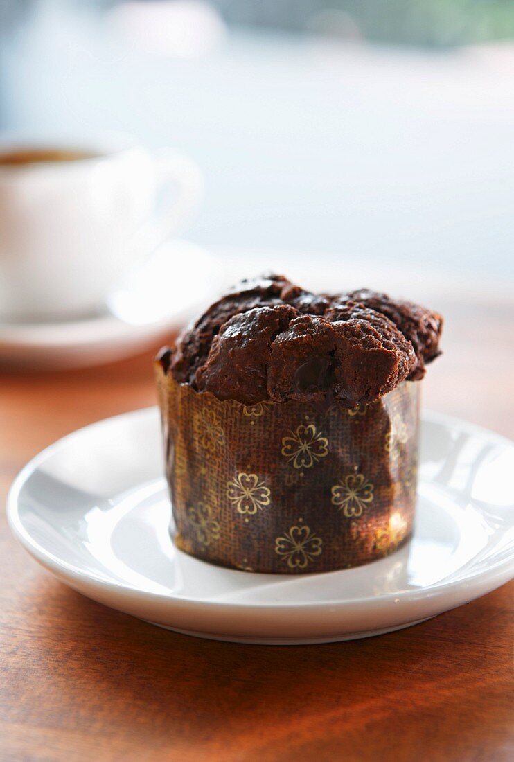 A mini chocolate muffin in a paper case