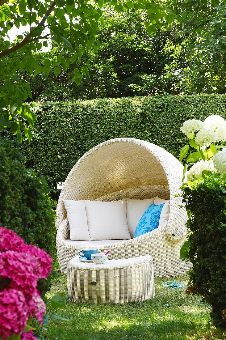 Luxuriöser Strandkorb mit Beistelltisch im Garten