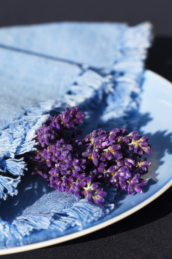 Blauer Teller mit Stoffserviette und Lavendelblüten