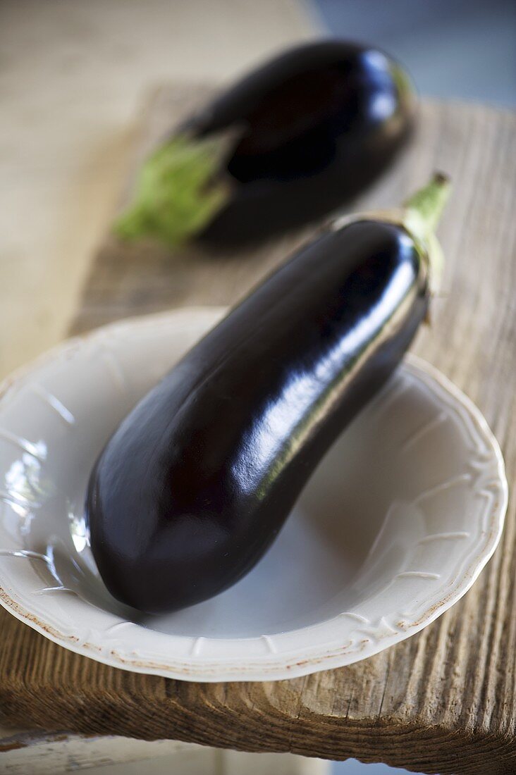 Aubergines on a plate and on a wooden board