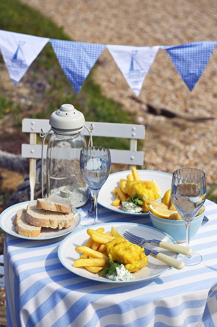 Fish and Chips auf Tisch am Strand