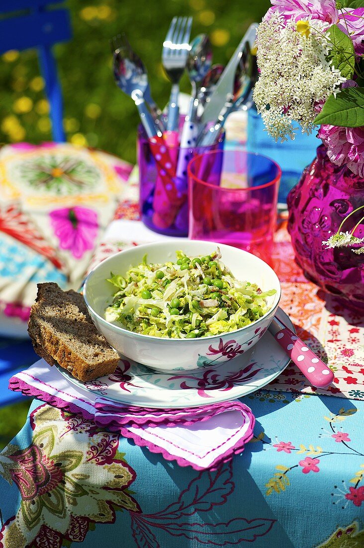 Blattsalat mit Erbsen auf Gartentisch