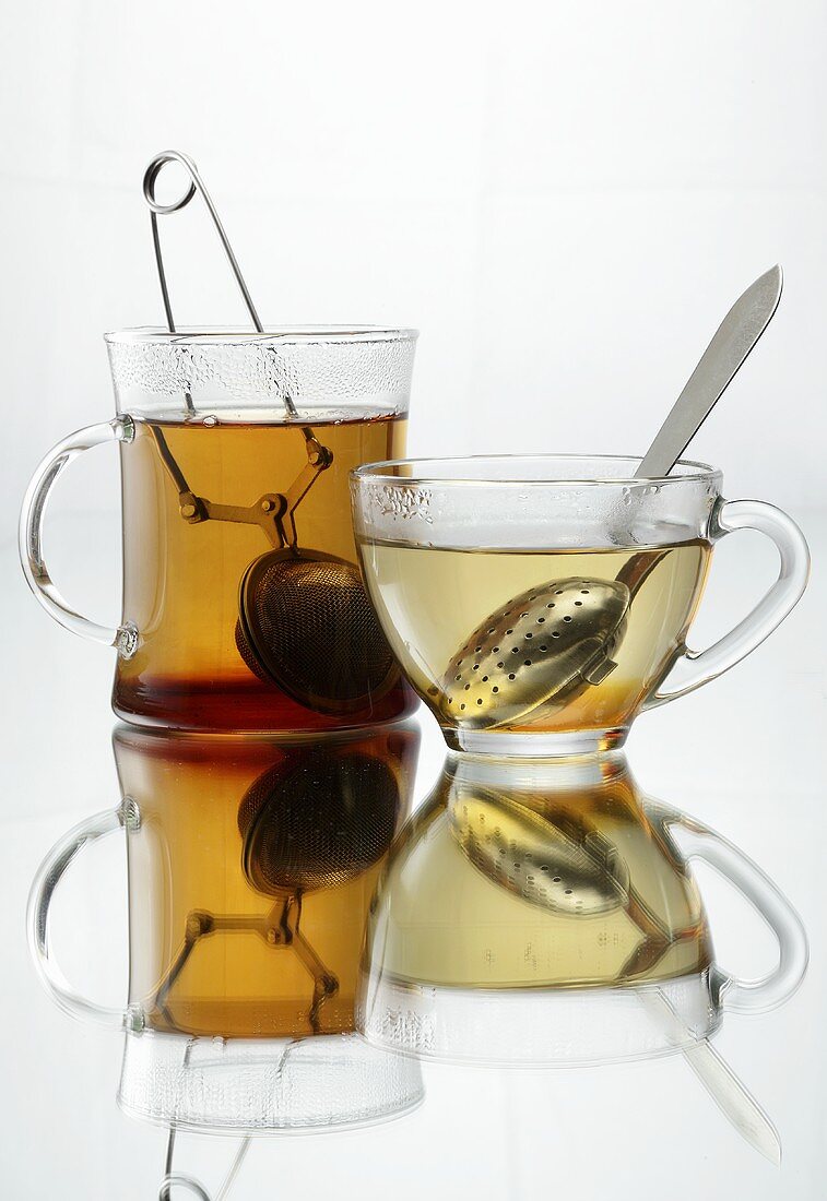 Tea in two different glass cups with infusers