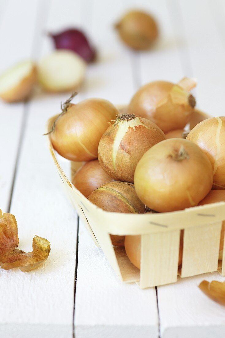 Brown onions in a wooden basket