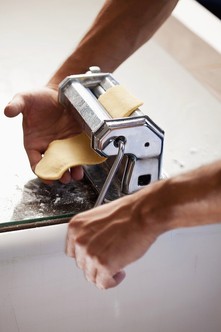 Passing pasta dough through a pasta maker