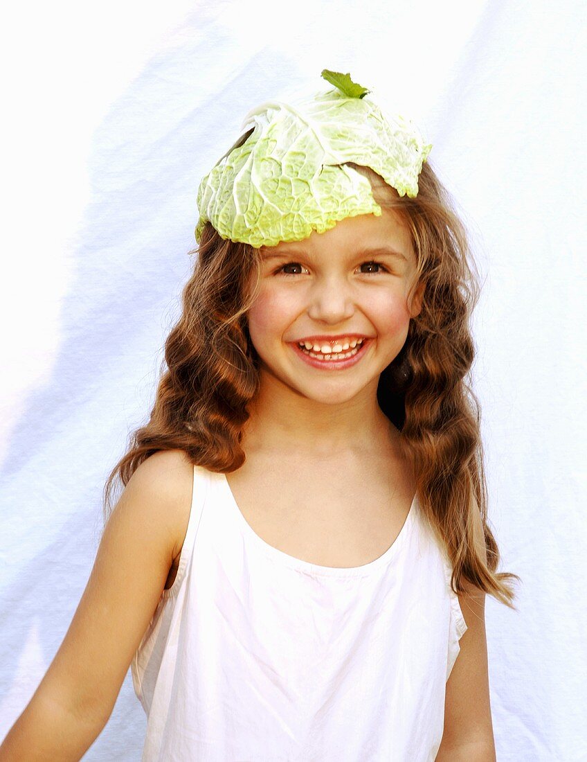 A girl with a cabbage leaf on her head