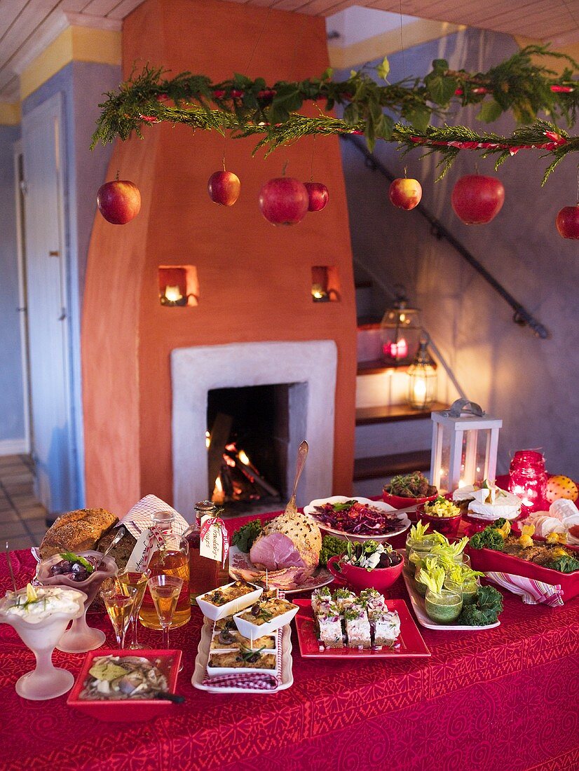A Christmas buffet in a decorated room in front of an open fire