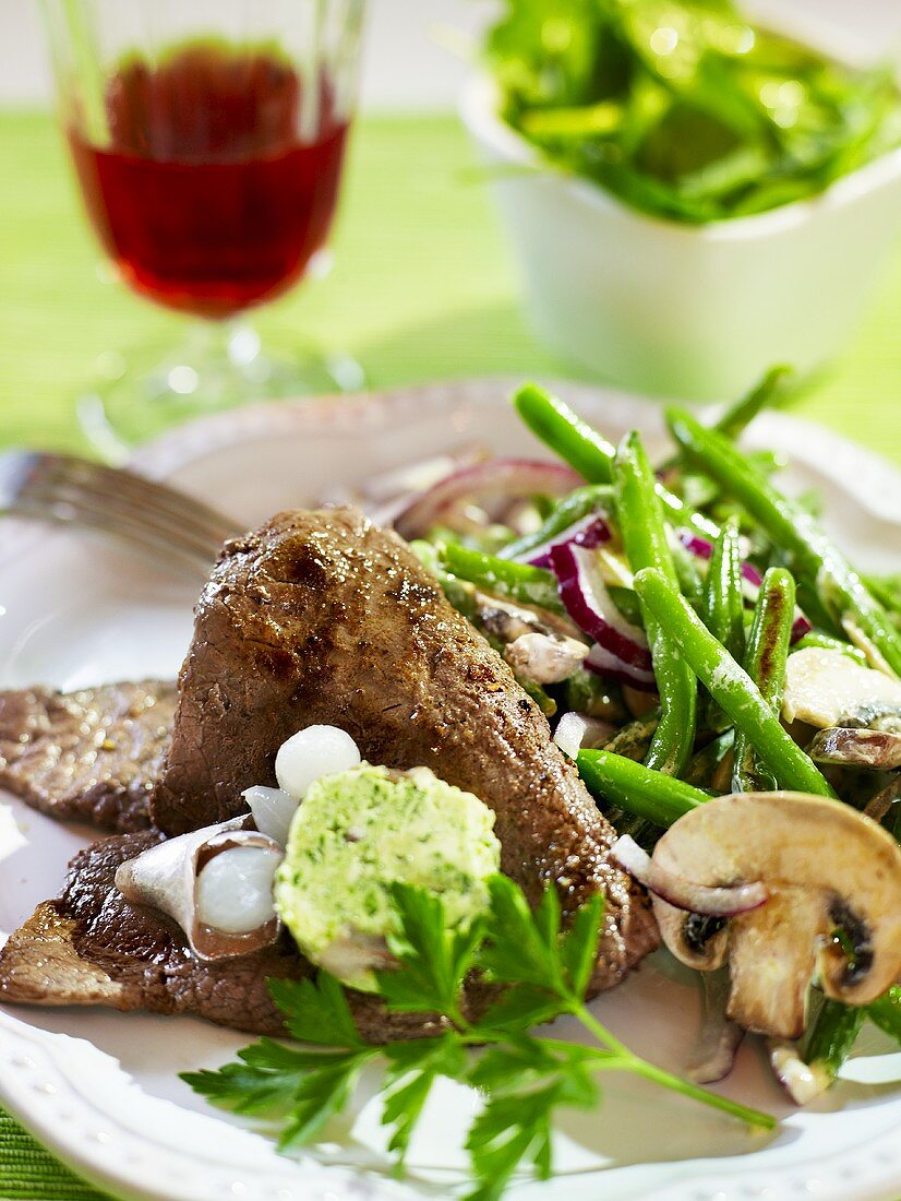 Minuten-Steak mit Kräuter-Anchovis-Butter, dazu Bohnengemüse