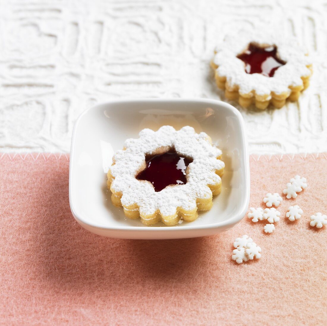 Linzer biscuits (nutty shortcrust jam sandwich biscuits with holes on top) with redcurrant jam