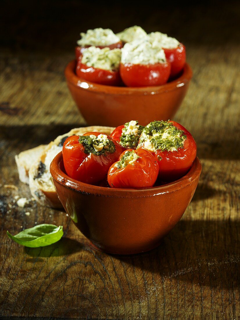 Cherry tomatoes stuffed with a herb and cream cheese filling and mini peppers stuffed with a pesto and cream cheese filling