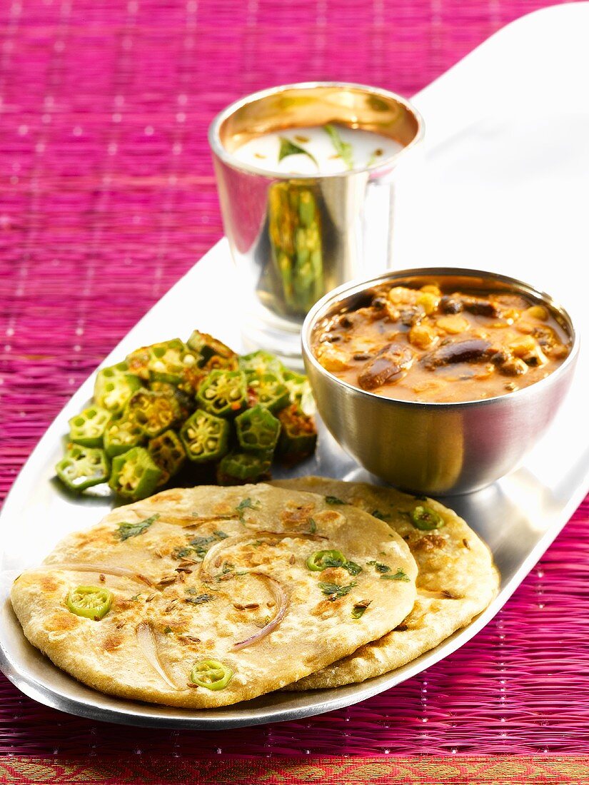Indische Küche: Paratha (Fladenbrot), Rajma (Kidney-Bohnen-Curry), Okra und Chaas (Buttermilch)