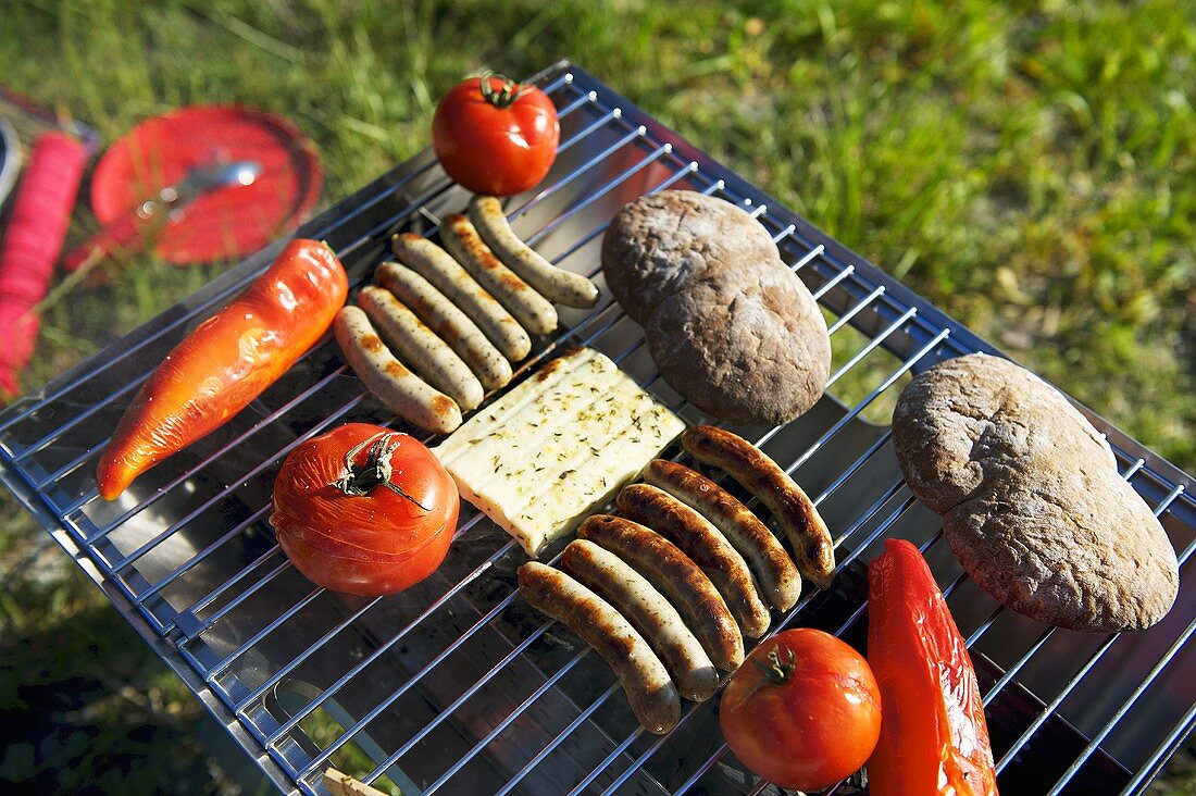 Sausages, cheese and vegetables on a barbeque
