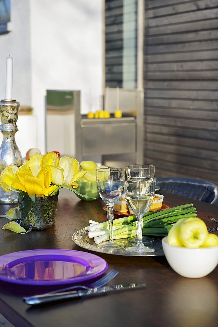 A laid table with a barbeque in the background